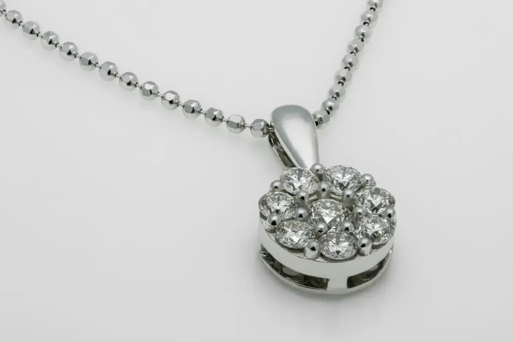 A close-up shot of a luxury diamond pendant necklace with a shiny metallic chain