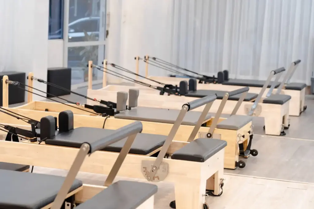A contemporary Pilates studio equipped with multiple wooden reformers for fitness training