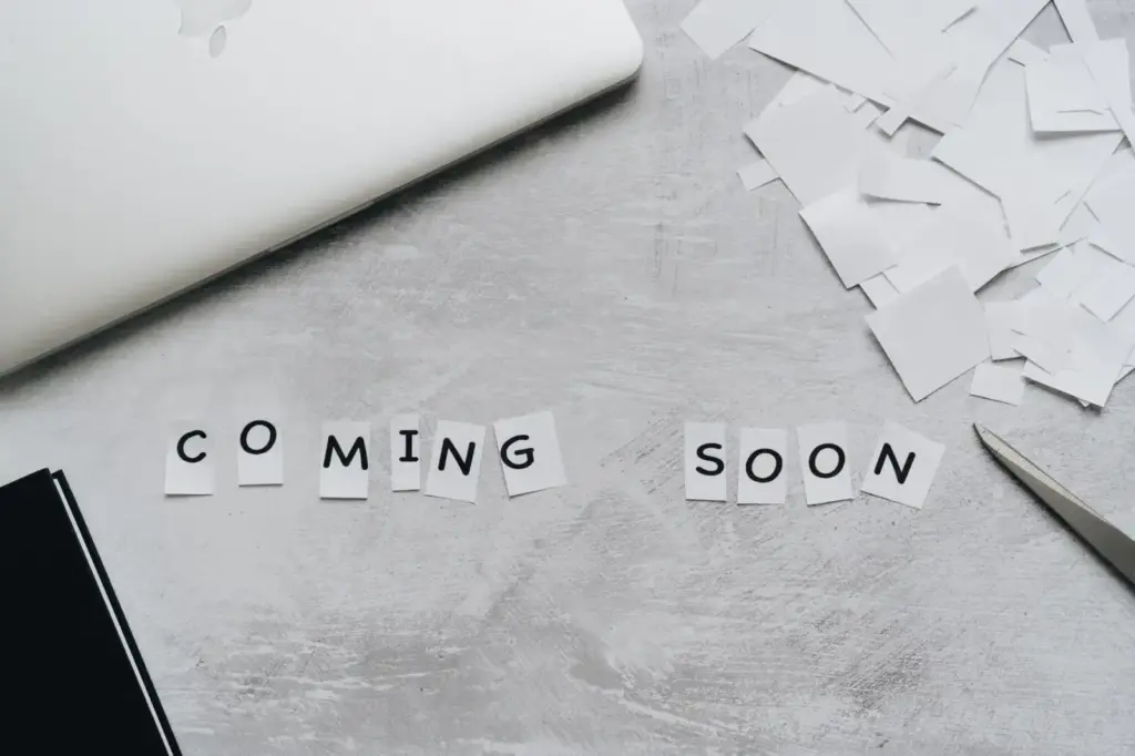 A creative arrangement with paper cutouts spelling 'Coming Soon' on a textured surface