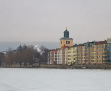 A serene winter view of Jönköping's lakeside with colorful buildings and a historic church