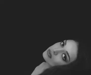 Black and white portrait of Tia Bajpai looking serious against a dark background
