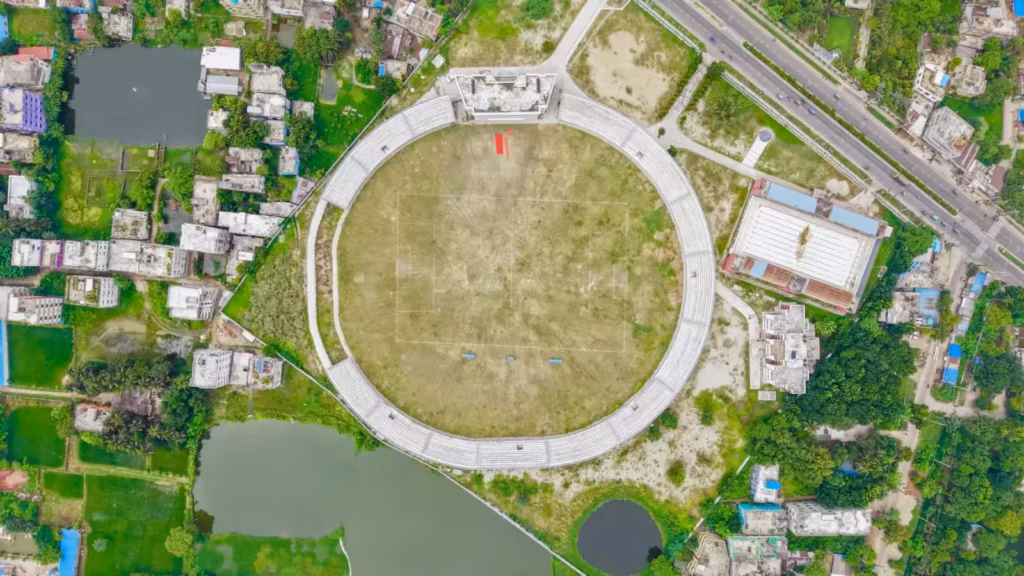 Aerial view of a large, empty circular stadium surrounded by urban buildings and roads