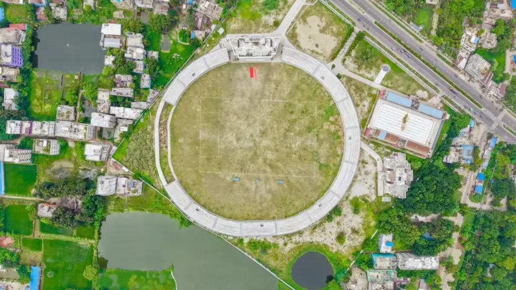 Aerial view of a large, empty circular stadium surrounded by urban buildings and roads