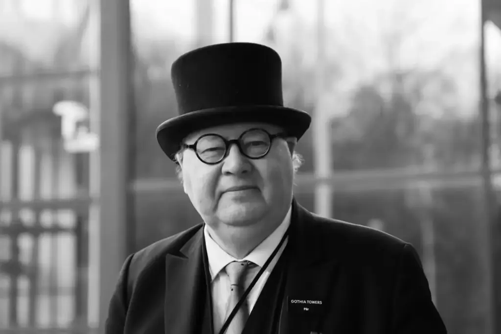 Black and white portrait of an elderly gentleman in Gothenburg wearing a hat and glasses