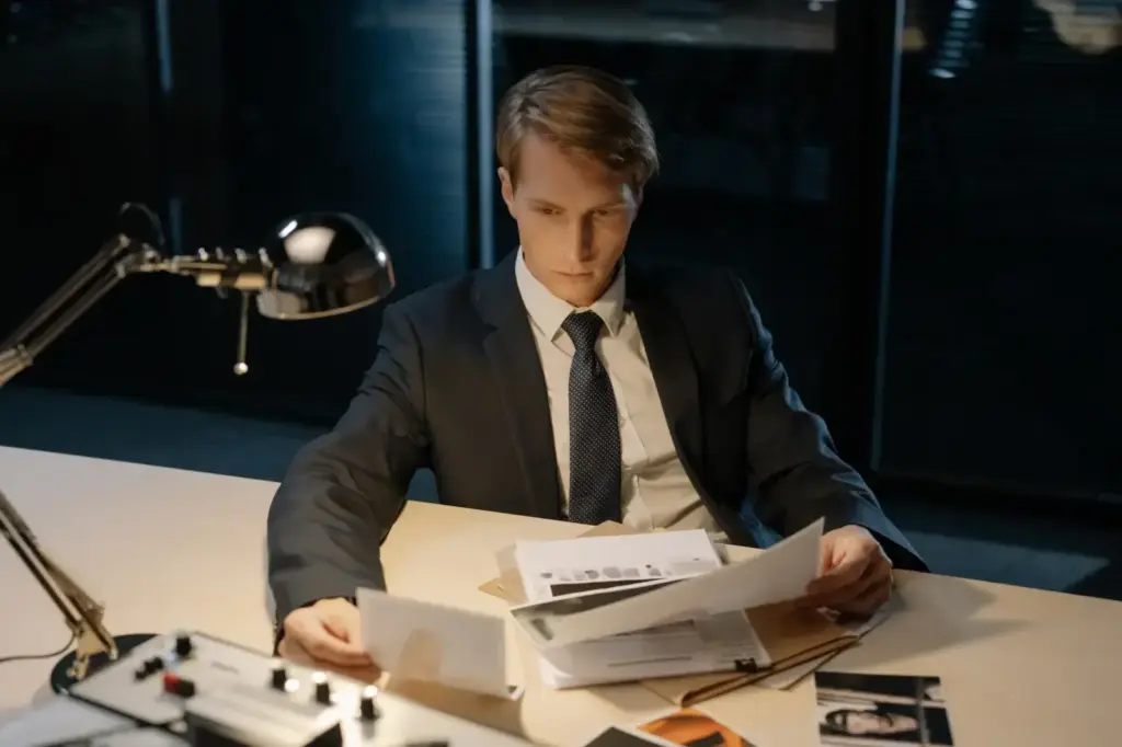 Focused investigator reviewing evidence in a dimly lit office setting