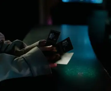 Moody image of a person holding cinema tickets at night, highlighting anticipation of a movie night