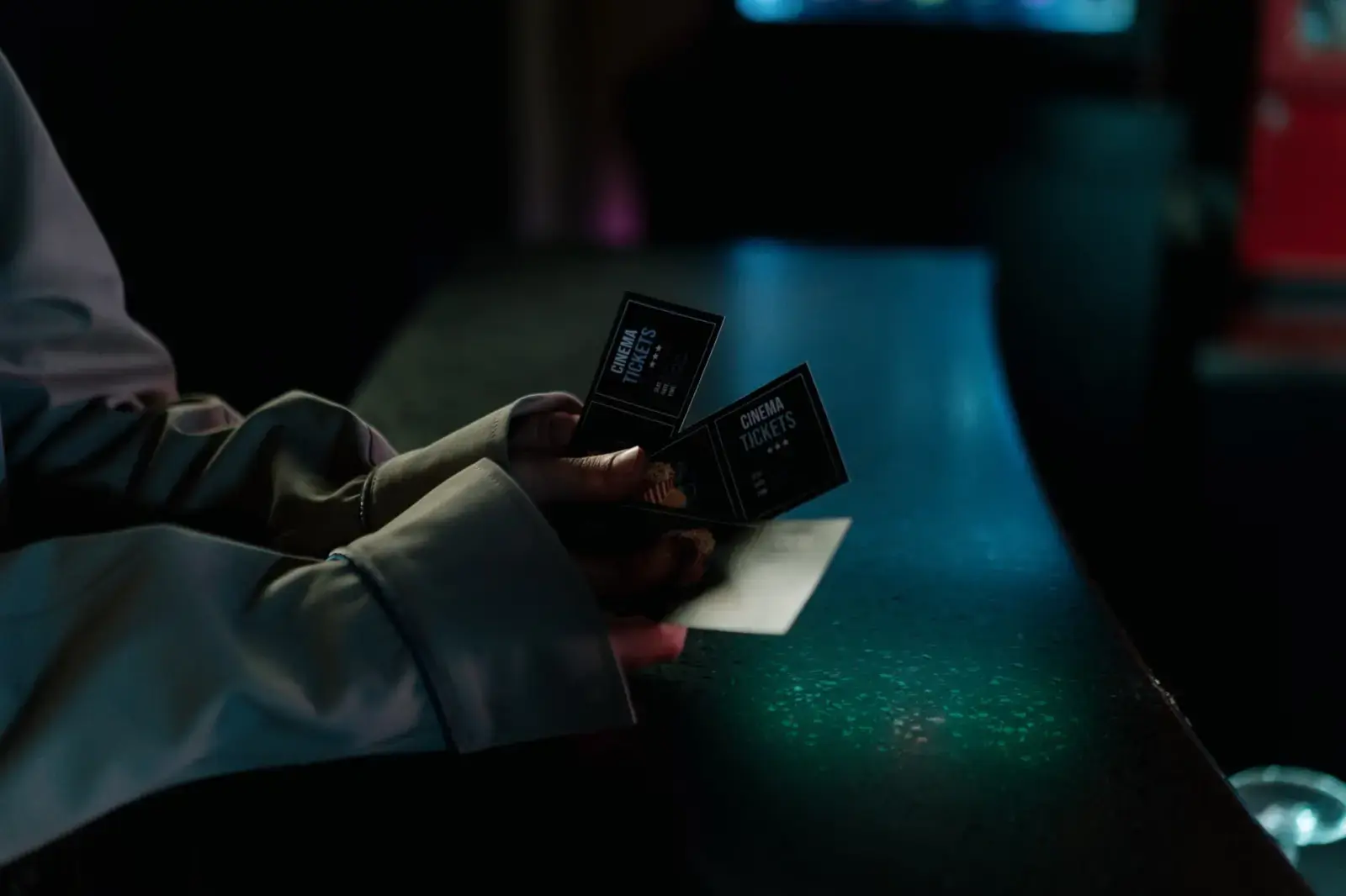 5 Best New Netflix Movies and Shows to Watch This Week Moody image of a person holding cinema tickets at night, highlighting anticipation of a movie night