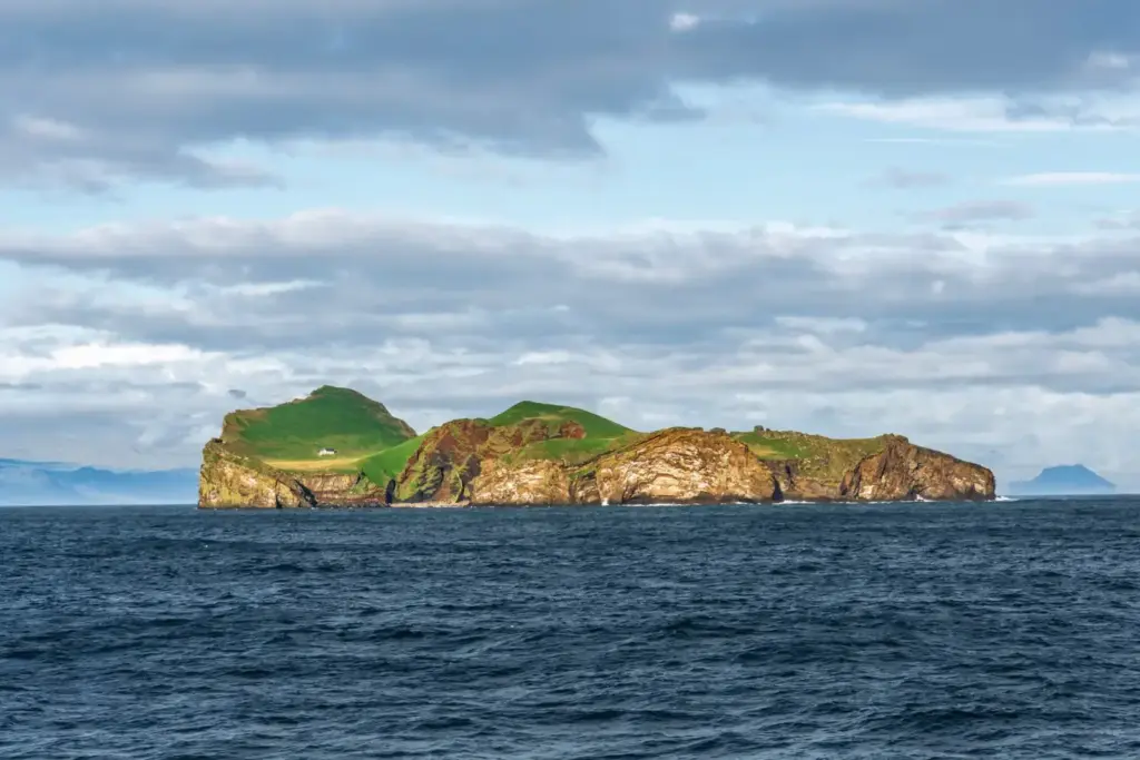 Rugged green coastal cliffs and grassy hills on an isolated island overlooking the ocean