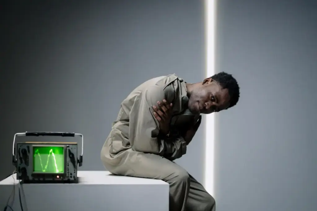 Portrait of a man posing next to an oscilloscope in a studio setting