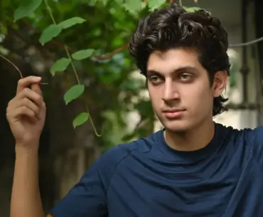 Young man posing outdoors in Islamabad with natural greenery background